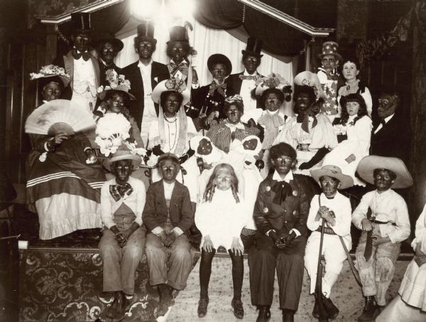 A group of children and adults pose in blackface at a Masonic party.