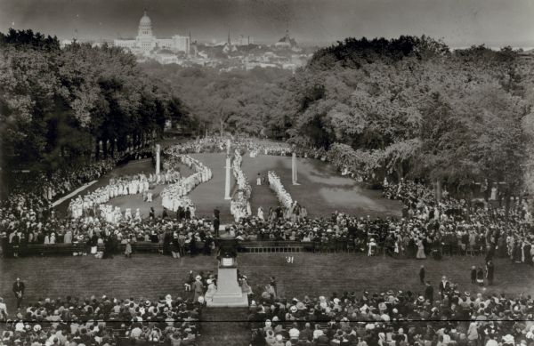 Maypole Dance at the May Fete on Bascom Hill. Just visible at the top of the photograph is the new Wisconsin State Capitol, completed except for the north wing, which was finished in 1917. In the foreground is the Lincoln Monument.