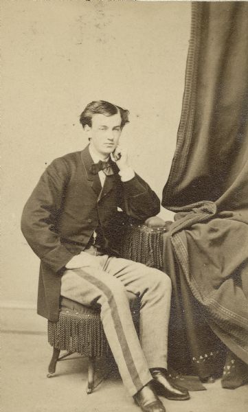 Studio portrait of young Fred Dennett with his chin resting on his hand, taken in the late 1860's.