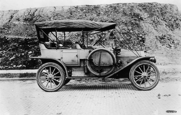 IHC Model J30 Touring Car parked by hillside. The J30, also known as the IHC "30" was manufactured in 1910 and 1911. A total of 1105 were built.