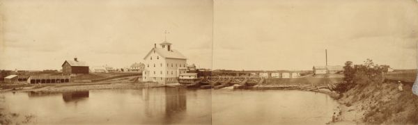 Panoramic view of the Knapp Stout and Co. flour mill, with a pond in the foreground. The mill was built in 1880 and was destroyed by a fire in 1911.