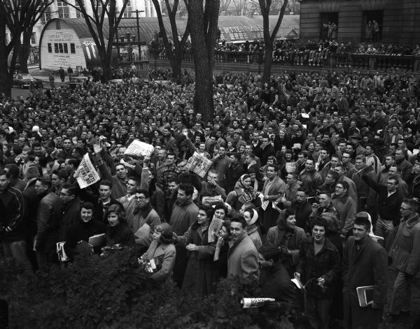 A crowd of University of Wisconsin students rally in front of the Memorial Union on getting a bid for the Rose Bowl. In 1952 the University football team won the championship of the "Big Ten" Midwestern university conference, and with it the right to compete in a game at the Rose Bowl in Pasadena, California.
