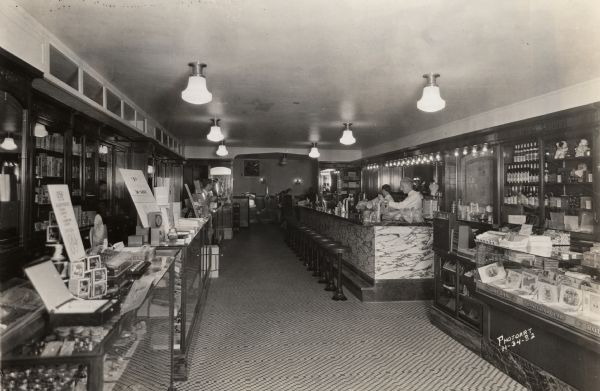 Interior of the Rennebohm Drug Store #7 at 901 University Avenue, with the soda fountain, two soda jerks, and the general sales area.