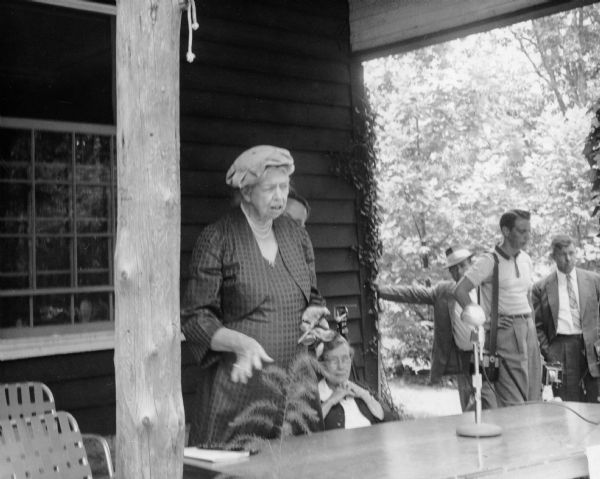 Eleanor Roosevelt speaks on the front porch of Highlander School. The woman seated behind Ms. Roosevelt is May Justus, who, with her partner Vera McCampbell, was very involved with the school.