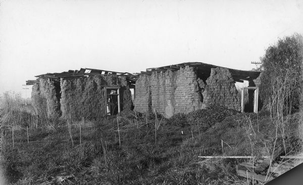 Exterior of a dilapidated sod house.