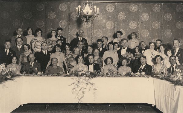 A wedding party poses at a banquet table. The man standing at the far right in a dotted tie is probably William B. Rubin.