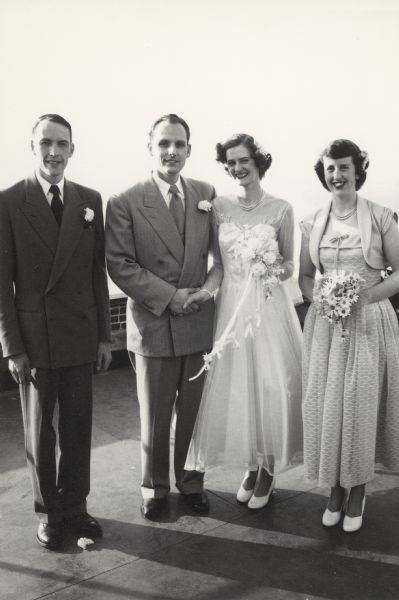 John Earl and Patricia (Salisbury) Earl at their wedding reception on June 23, 1951 at the Edgewater Hotel.  Flanked by best man Robert Salisbury, Jr. and maid of honor Barbara Salisbury (later Mrs. Don Kaiser), Patricia's brother and sister.  John's brother and niece were killed the morning of the wedding in a car accident.  His sister-in-law survived, but with brain damage.  The wedding dress (2005.68.1) was purchased at a store in Milwaukee and is now part of the Wisconsin Historical Museum's collection.