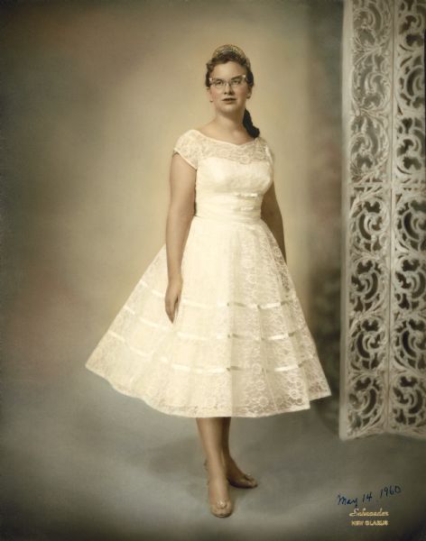 Sixteen-year old Linda Schiesser poses in the outfit she wore at her installation as a Worthy Advisor of the New Glarus International Order of the Rainbow for Girls, a division of the Masons. The dress (2005.129.5.1), purchased at Sears, is now part of the Wisconsin Historical Museum's collection.