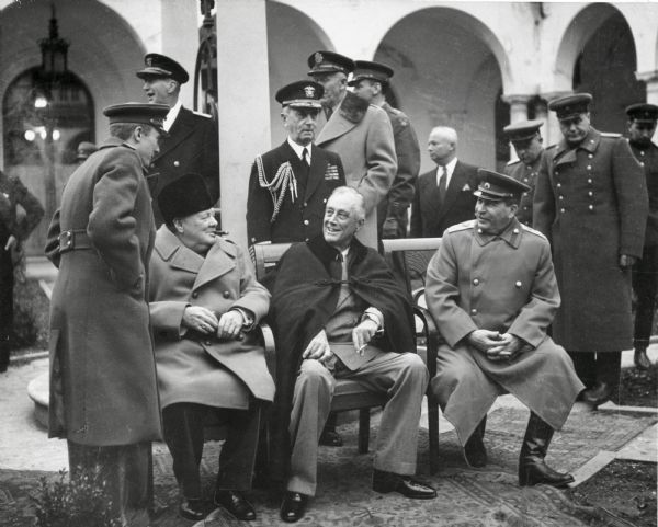 Prime Minister Winston Churchill, President Franklin D. Roosevelt, and Premier Joseph Stalin seated on the patio of Livadia Palace, Yalta, Crimea, Russia, as they gather for a conference. Admiral William Leahy, FDR's personal chief of staff, stands behind the President. Leahy was raised in Ashland, Wisconsin.