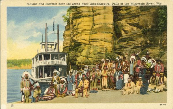 Winnebago (Ho-Chunk) Indians posing in front of the steamboat <i>Winnebago</i> near the Stand Rock Amphitheater. This is where the Stand Rock Indian Ceremonial is performed. Caption reads: "Indians and Steamer near the Stand Rock Amphitheatre, Dells of the Wisconsin River, Wis."
