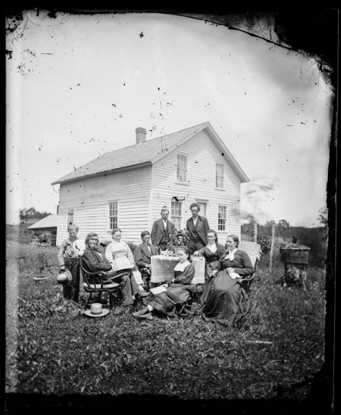The Andrew Amundsen family is posed around a table adorned with a knit cloth. Andrew and his wife, Sarah, are in rocking chairs with cloths over the backs. Their frame house is behind them. The 1870 census listed the Andrew Amundsen family as consisting of Andrew, 52; Sarah, 45; Gjertrud, 18; Lausa, 15; Helena, 12; Lewis, 9; and Susania, 7. Andreas Larsen Dahl married Gjertrud Amundsen, second from right, in August 1878.