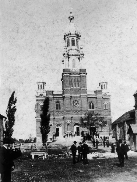 The third Sacred Heart Church, built in 1901. Exterior view with people in front of the building.
