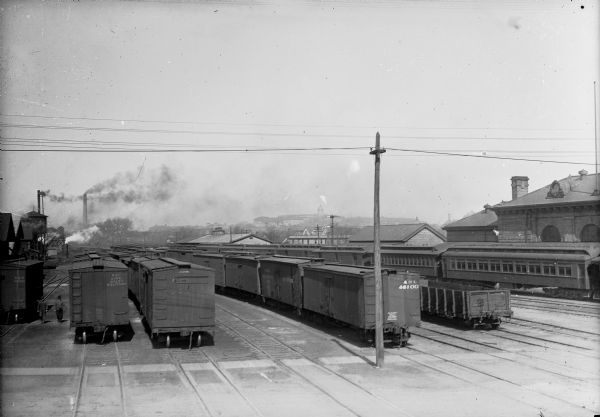 Slightly elevated view of railroad trains and cars parked in a railroad yard.