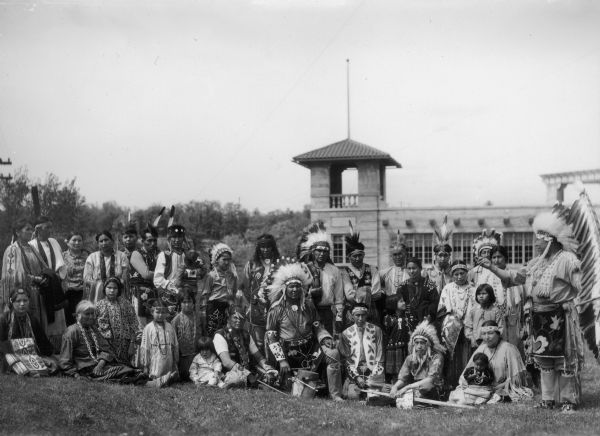 Group of Native Americans en route to the 1933 World's Fair.  The group are members of the Stand Rock Indian Ceremonial. The man holding the feather flag on the right is Ho-Chunk Chief Albert Yellow Thunder. 