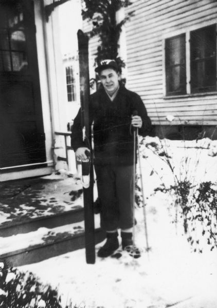 Winter scene with Wayne T. Vanderhoef (1929-1997) posing with his skis in front of 312 North Butler Street, Madison, Wisconsin.
The Wisconsin Historical Museum has the skis and ski poles in its collection (2005.143.2a-b, 2005.143.4a-b)