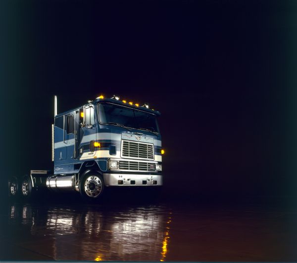 Color studio photograph of the passenger side of an International Transtar Eagle semi tractor.  The truck features a blue and light blue color scheme with extensive pinstriping.