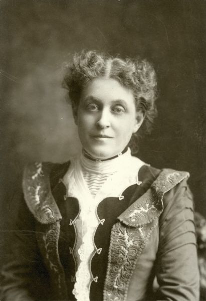 Waist-up portrait of Carrie Chapman Catt, one of the best known leaders of the women's suffrage movement who had strong ties to the North Country and who once "inflamed" the countryside with her oratory.  Carrie Lane was born in Ripon, Wisconsin, on January 9, 1859, the daughter of Lucius Lane and Maria Clinton Lane. Both of her parents had graduated from Potsdam Academy, and several generations of the Lane family had farmed the family homestead in West Potsdam, NY for many years. Lucius and Maria had gone west in 1855, soon after their wedding, but both families remained well-known locally. Catt's girlhood home is the site of the future Carrie Chapman Catt Museum.  Carrie worked as an organizer for the National American Woman Suffrage Association from 1890 to 1900, when she became its national president. She led the campaign to win women's suffrage with a federal amendment to the constitution until 1920 when the 19th amendment was ratified.