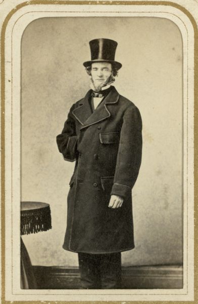 Carte-de-visite portrait of Darwin Clark, standing and wearing a long coat and a top hat. Clark arrived in Madison, Wisconsin, in 1837, to work on the construction of the territorial capitol.