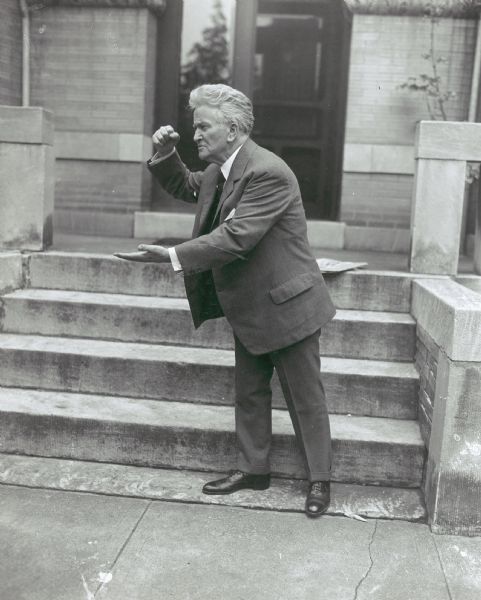Robert M. La Follette, Sr., striking an emphatic pose with his fist raised over his hand. This photograph was probably taken for publicity purposes during La Follette's independent Presidential campaign.  In it, La Follette is standing on the steps of a building in Washington, D.C.