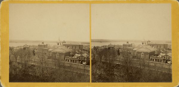 Stereograph of view from the Capitol looking southwest by south. In the foreground are the Capitol Park, the First Baptist Church on Carroll Street; and beyond, the Dane County Courthouse and St. Raphael's Catholic Church (steeple not yet constructed), on Main Street. Lake Monona and Monona Bay are in the distance. Until it moved into the Capitol in 1866, the Wisconsin Historical Society rented space in the basement of the Baptist Church.