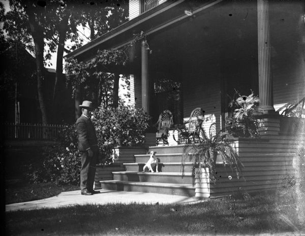 Albert Zimmerman and his dog at the front steps that lead to the porch of his house at 746 East Gorham Street.