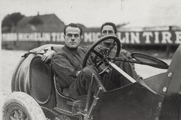Driver David Bruce-Brown and mechanic Tony Scudelari pose in their race car. Although they had been warned that their tires appeared worn, on October 1, 1912, they continued to practice for Bruce-Brown's third American Grand Prize Race (held on October 5). When a tire on their Fiat burst, the car went cartwheeling into a ditch. Bruce-Brown (only 22 years old), died almost instantly and Scudelari succumbed to his injuries about a week later.