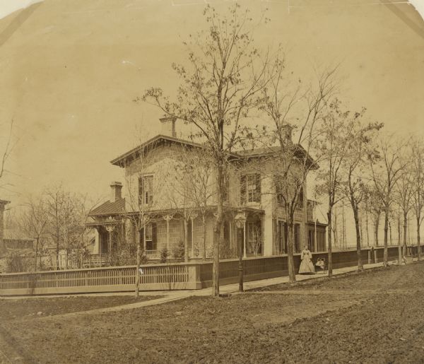 The residence of Napoleon B. Van Slyke at 510 North Carroll Street. The caption reads: "Maie on piazza with doll. Jonnie in baby carriage."