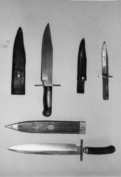 Three bowie knives, including sheaths.