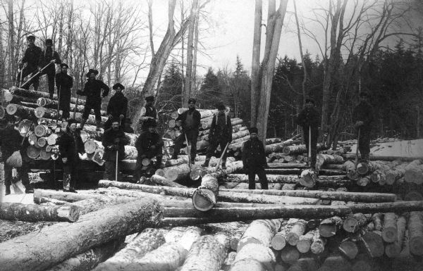 A group of Native American Indian loggers pose on piles of logs at the Courtes Oreilles Reservation.
