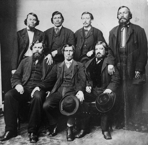 Portrait of French Indian men who made the trip to Washington via the Mississippi River to sign the 1854 Treaty ceding lands in both Minnesota and Wisconsin. In the back row are Frank Roy, Vincent Roy, E. Rousain, and Frank Rousain. Sitting in the front row are Peter Roy (Territorial House 1854 (District 5); House 1859-60 (District 21); House 1862 (District 3), Joseph Gourneau, and D. George Morrison.