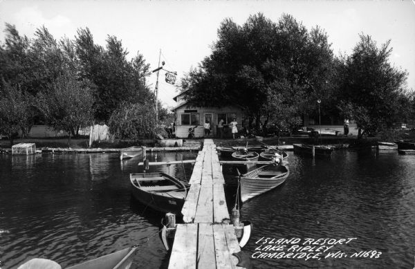 View from a pier of rowboats and a cabin at the Island Resort on Lake Ripley.