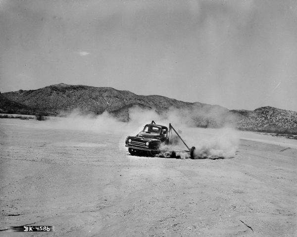 International pickup kicking up dust on a dirt test track at International Harvester's Phoenix Proving Ground. Opened in 1947, the proving ground was used by International Harvester through the 1970's to test trucks and construction equipment under harsh desert conditions.