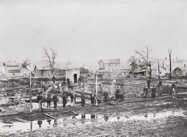 People gather the morning after a fire that destroyed Dixon's store as well as $100,000 worth of goods and eleven other places of business. The flames were visible for twenty-five miles.