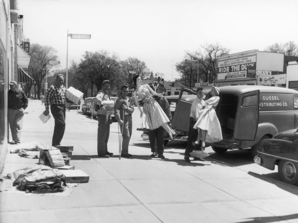 Men loading mannequins into a truck during the move of Arlene's Apparel shop.