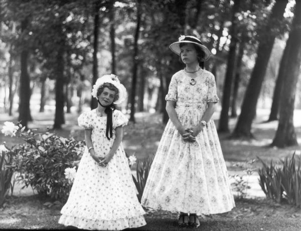 Helene Greenwood and Jean Dyer pose wearing hats and long dresses at the Bowman Park dedication.