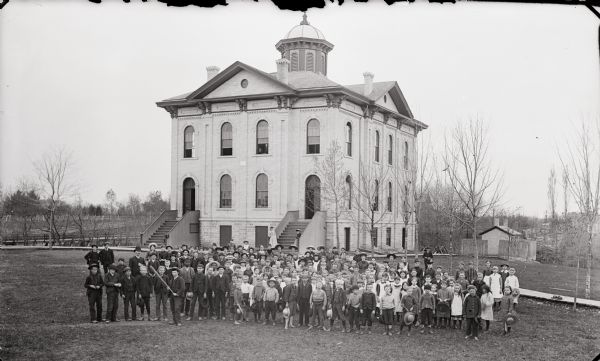 Outdoor group portrait of students and teachers posing in front of the Kilbourn School.