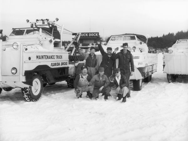 Six men pose in front of trucks loaded with Wisconsin Dells' local land/water vehicles known as the Ducks.