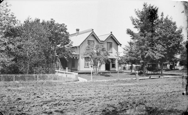 Exterior view of the Glen Cottage-Crandall Hotel. A carriage is parked under trees on the right.
