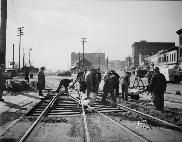 Railroad construction crew working on a Chicago & Northwestern Railroad crossing, looking west up the 400 and 500 blocks of East Wilson Street.