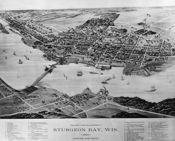 Bird's-eye map of Sturgeon Bay, looking Northeast. Area bordered by Church Street in top left corner, leather & Smith Bridge in bottom left corner, Lawrence Street top right corner, and Main Street bottom right corner; one bridge spans water with many steam and sailing ships.  Fifty-three locations identified in location key below image.