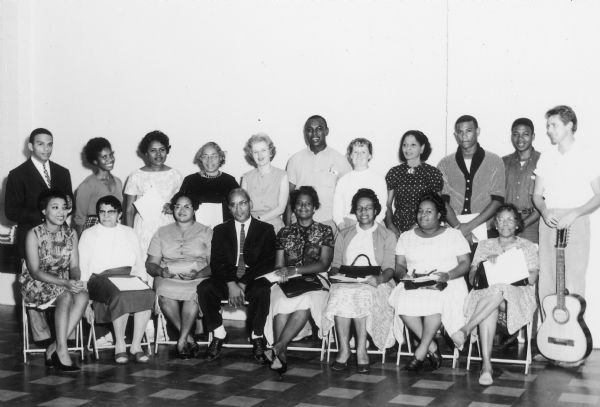Group portrait of staff from Highlander School, including Andrew Young (far left), Septima Clark (4th from left), Aimee Horton, Bernice Robinson, and Guy Carawan (with guitar), Dorothy Cotton (front row left), Candie Carawan (seventh from left).