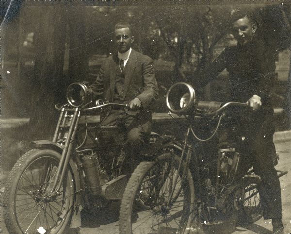 Two men posed with motorcycles.