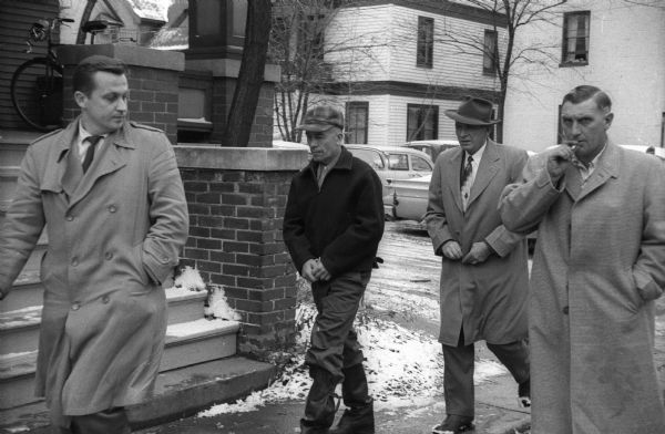 Ed Gein (1906-1984) is escorted by three law enforcement officers to the State Crime Laboratory, 917 University Avenue for lie detector and other tests.
