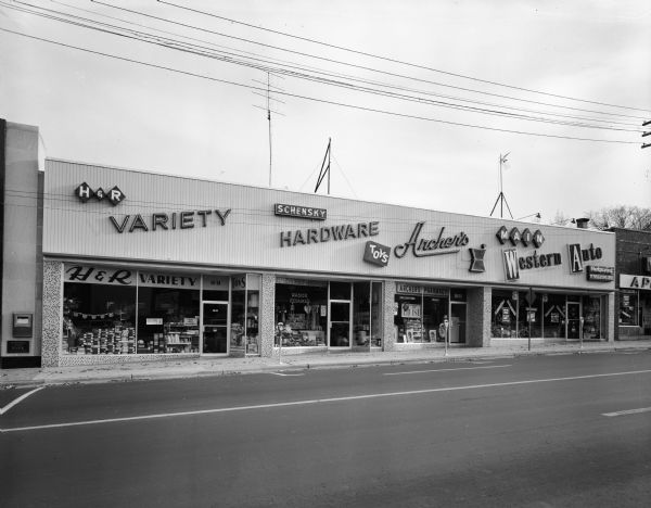 Exterior view of businesses along 1831-1841 Monroe Street, including: H & R Variety store, Schensky Hardware, Archer's Pharmacy and Main Western Auto.