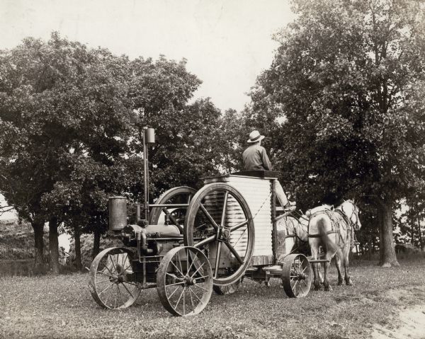 Horses pulling a very early water-cooled Titan engine, one of the first models manufactured by International Harvester.
