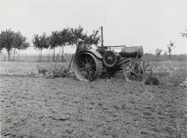 Farmer pulling a P&O plow with a Titan tractor. The original caption reads: "Ira Wolf's farm, Aurora Ill., P&O plow."