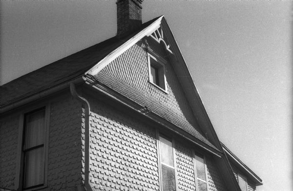 A house at 715 East Gorham Street which has triangular shingles on the upper story and rectangular shingles on the lower story.
