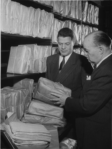 State Historical Society of Wisconsin Director Clifford Lord (left) and McCormick Collection Director Herbert Kellar examining packages of manuscripts. The manuscripts were part of the McCormick Collection, which had just been donated to the Historical Society by Anita McCormick Blaine.