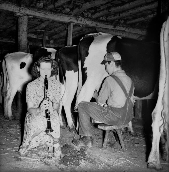 Member of local farmers band practicing clarinet in barn.