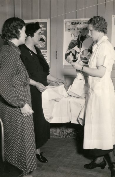 A nurse is talking to two pregnant mothers.